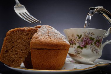 Kek, porselen ve gümüş çaydanlık.