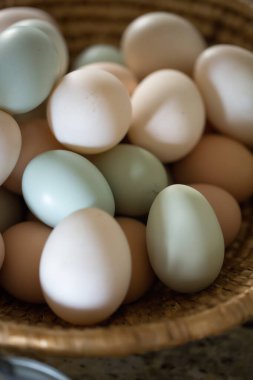 Tezgahta dokuma sepetinde çeşitli taze çiftlik yumurtaları..