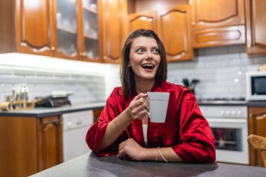 Evde kırmızı pijamalı genç bir kadın var.