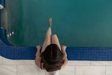 Otel havuzunda hamile bir turist bebek ayı tatilinin tadını çıkarıyor.