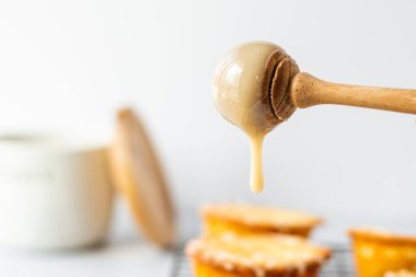 Tatlı keklerin üzerine bal damlatan bir bal damlası
