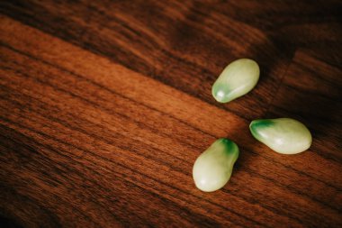 Ahşap yüzeye dizilmiş yeşil Roman domatesleri