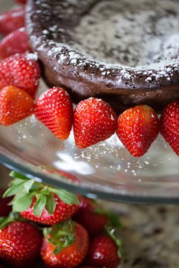 Pudra şekerli çikolatalı pasta ve taze çilek..