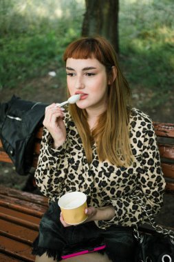 Leopar desenli kızıl saçlı, Bench 'te dondurmalı.