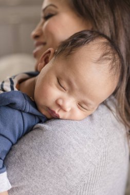 Uyuyan bebek annesinin omzunda huzur içinde yatıyor.