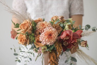 Gelin bohem stili düğün buketini toprak renginde tutuyor.
