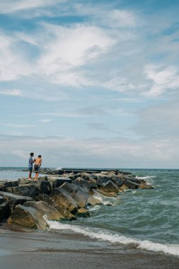 Dostlar sahildeki kayalık iskelede günün tadını çıkarın.
