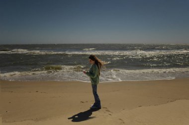 OBX plajında sosyal medyayı kontrol eden güzel bir genç.