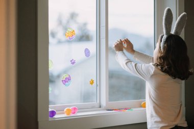 Paskalya çıkartmaları ve yumurtalarla çocuk dekorasyonu penceresi.