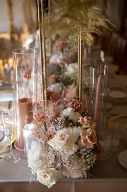 Allık mumlar ve altın aksanlı zarif çiçek süsü.