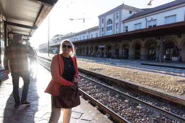 Öğleden sonra Bozen tren istasyonunda bir kadın bekliyor.