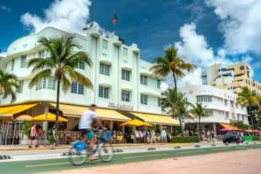 Miami Florida halkı Ocean Drive 'daki Art Deco otelleri boyunca bisiklet sürüyor.