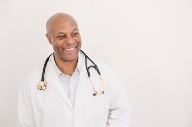 Steteskoplu beyaz önlüklü gülümseyen doktor.
