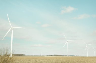 Çoklu rüzgar türbinleri kopya alanı olan açık bir Indiana sahasında duruyor.