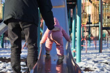 Milenyum Babası Kızına Karlı Oyun Bahçesinde Yardım Ediyor