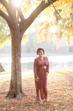 Sonbahar yaprakları arasında yürüyen kadın