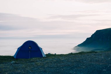 Lofoten 'da sisli bir uçurumun kenarına kurulmuş mavi çadır.