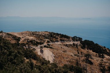 Arnavutluk 'ta kıyı manzaralı otoyol boyunca uzanan virajlı dağ yolu SH8