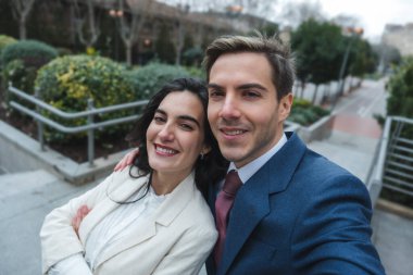 Gülümseyen iş çifti şehir ortamında selfie çekiyor