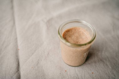 Ekmek pişirmek için ekşi ekmek başlatan cam bir kavanoz.