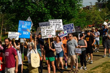Siyasi bir gösteride pankart taşıyan yürüyüşçüler