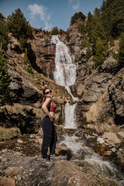 Şelalenin önünde poz veren kadın