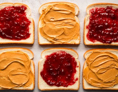 Üst manzara fıstık ezmesi ve beyaz ekmek dilimleri üzerine reçel..