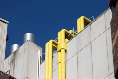 Beton sanayi binasının sarı çatı boruları