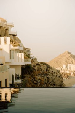 Cabo San Lucas kıyı şeridi ve deniz manzaralı güneşli kayalık villalar.