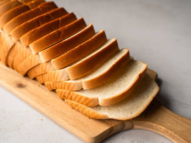 Dilimlenmiş beyaz ekmek somununu ahşap kesim tahtasına yakın tut..