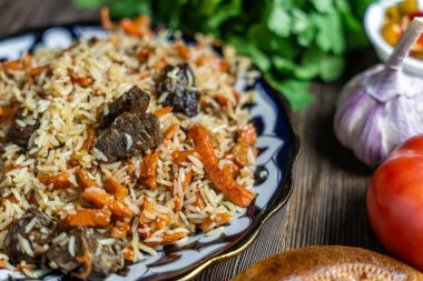 Ahşap zemin üzerinde Özbek festival pilavı olan büyük tabak