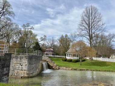 Huzurlu kasaba parkında çardağın yanında taş kanal kilidi ve şelale.