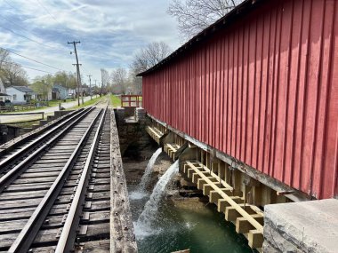 Kanal üzerinde akan suyla kırmızı kaplı köprü ve demiryolu