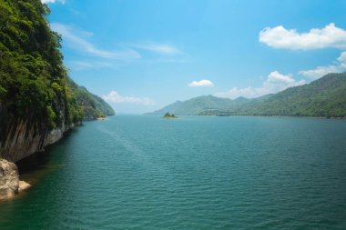 Dağlarla çevrili su ve parlak mavi gökyüzü
