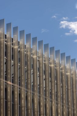 Mavi gökyüzünü yansıtan metal güneş gözlüklü modern bina