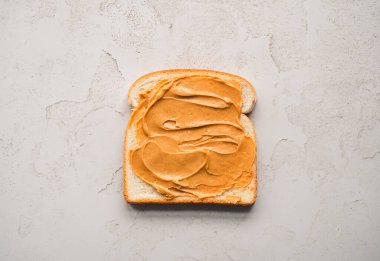 Fıstık ezmesi beyaz ekmeğin üzerine serpilmiş..