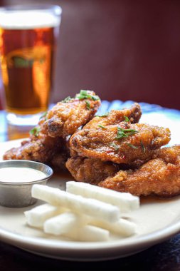 Sosa bulanmış, dikey bira kaplı tavuk kanatları.