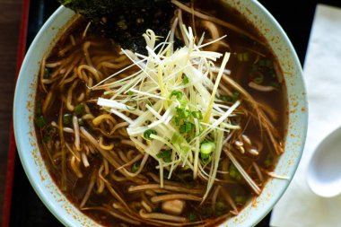 Bir kase garnitürlü ramen çorbası içiyorum.