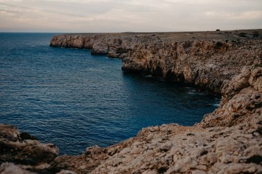 Sahil Kayalıkları ve Derin Mavi Deniz Sunset, Pont den Gil, Menorca