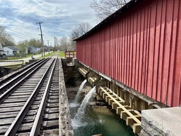 Kanal üzerinde akan suyla kırmızı kaplı köprü ve demiryolu