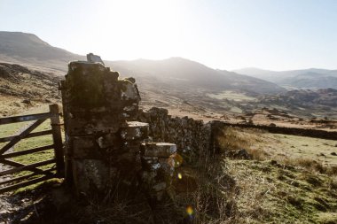 Sabah ışığında vadiye bakan taş duvar ve kapı, Coniston