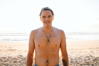 Gündoğumunda gülümseyen üstsüz adam Manly Beach, Avustralya 'da