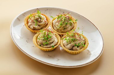 Patatesli tartlar ve tabakta otlar.