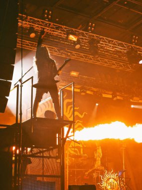 Gitarist sahnede bir rock konserinde havai fişeklerle performans sergiliyor.