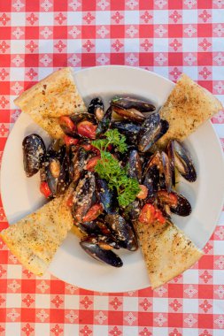 Damalı arkaplan köşesinde midye kasesi;