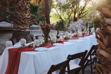 Kırmızı aksanlı ve mumlu kırsal bir ziyafet masası..