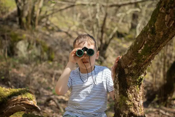 Oğlan kuşları dürbünle gözlemliyor.