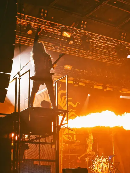 Gitarist sahnede bir rock konserinde havai fişeklerle performans sergiliyor.