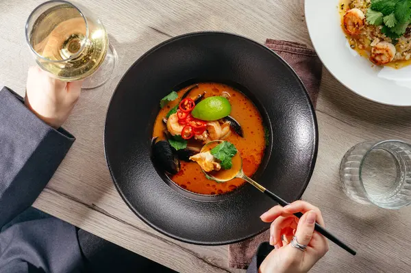 Lokantada bir bardak şarapla Tom Yum çorbası