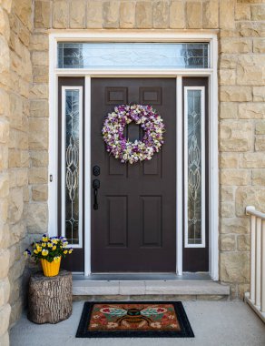 Evin ön kapısı bahar için çelenk ve çiçeklerle süslenmiş..